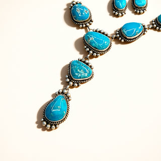 Silver jewelry with turquoise stones on a beige background