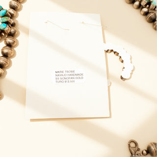 Jewelry with a card displaying 'Marie Tsoose' and 'Navajo Handmade' on a beige background