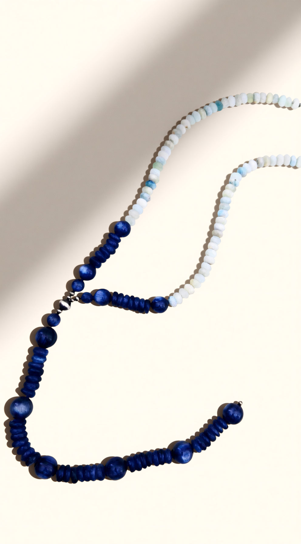Necklace with blue and white beads on a neutral background