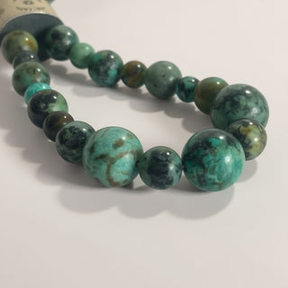 Turquoise and black beaded bracelet on a white background