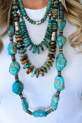 Turquoise beaded necklace with silver accents on a white background