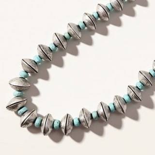 Necklace with blue and silver beads on a white background