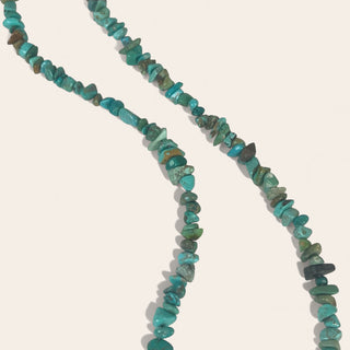 Turquoise beaded necklace on a light gray background