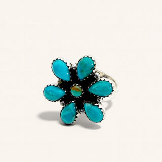 Turquoise flower-shaped ring on a white background