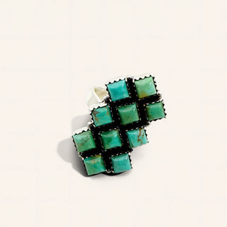 Ring with turquoise square stones on a white background
