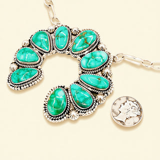 Turquoise stone necklace with silver clasp on a beige background
