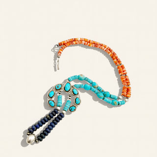 Necklace with orange, turquoise, and blue beads on a beige background