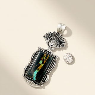 Silver pendant with colorful stone on a beige background