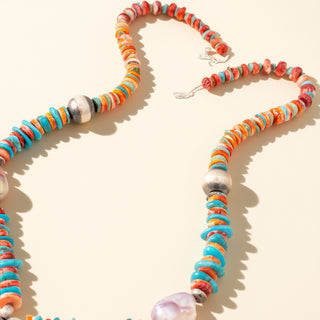 Necklace with multi-color stones and pearls on a beige background
