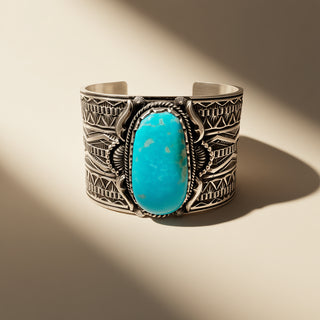 Silver bracelet with a turquoise stone on a beige background