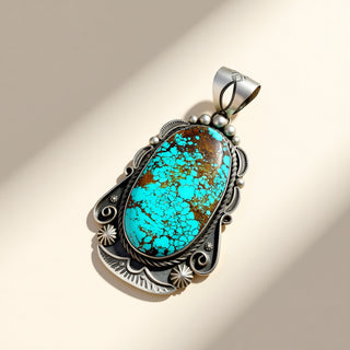 Turquoise pendant with silver setting on a beige background