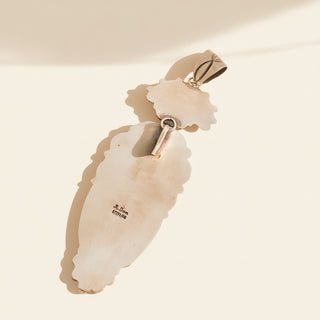 Silver  pendant on a beige background