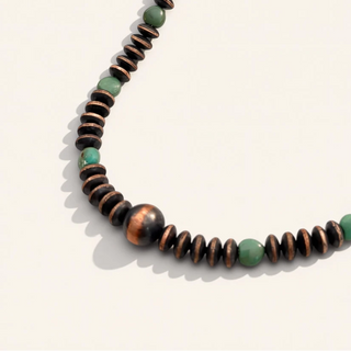 Necklace with brown and green beads on a white background