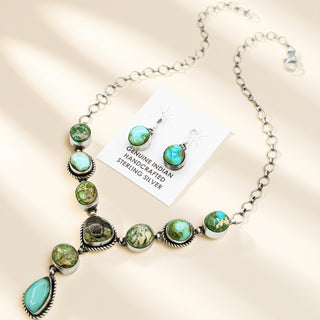 Necklace with green stones and silver accents on a beige background