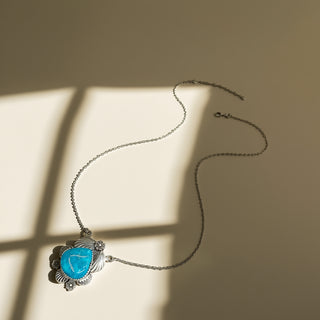 Necklace with a blue stone pendant on a beige background