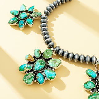 Black pearl necklace with turquoise pendants on a beige background