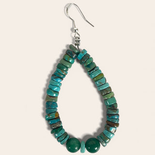 Turquoise beaded earring on a light gray background