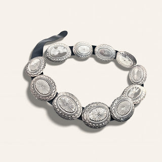 Silver bracelet with circular designs on a light gray background
