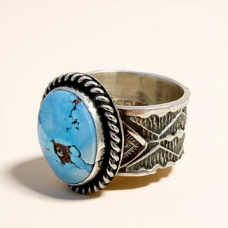 Silver ring with blue stone on a beige background