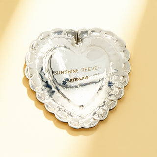 Silver earring with stamp on a beige background