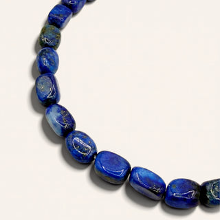 blue beaded jewelry on a beige background