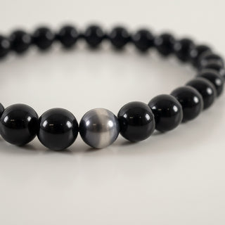 Black and gray beaded bracelet on a light background