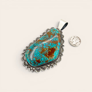 Turquoise pendant with silver border on a white background