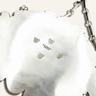 silver jewelry with 'Alex Sanchez Sterling' stamp on a beige background