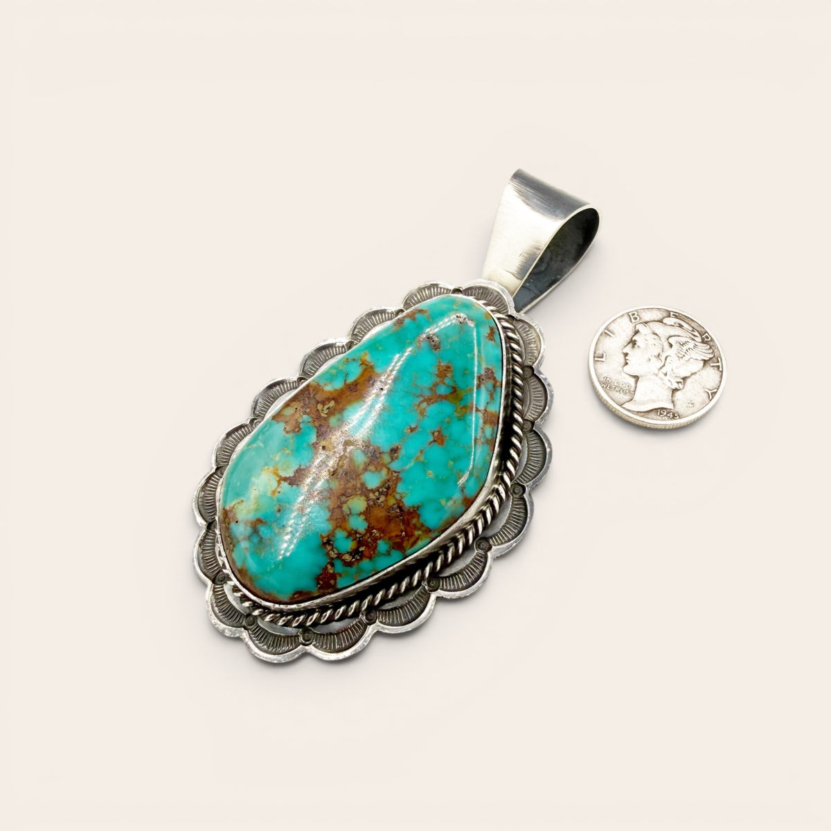 Turquoise pendant with silver frame on a white background