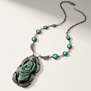 Necklace with turquoise stones and a central pendant on a white background