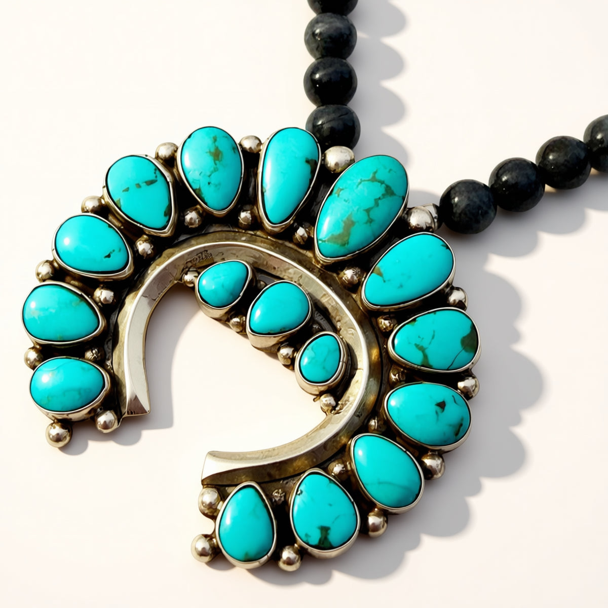Necklace with turquoise stones and black beads on a white background