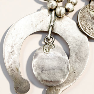 close up of silver jewelry on a beige background