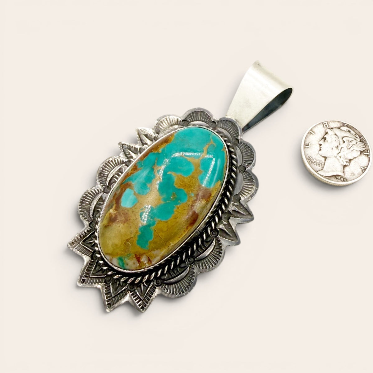 Turquoise stone pendant with silver setting on a white background