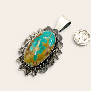 Turquoise stone pendant with silver setting on a white background