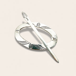 a sterling silver hair accessory on a beige background
