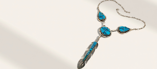 Necklace with turquoise stones and feather design on a light background