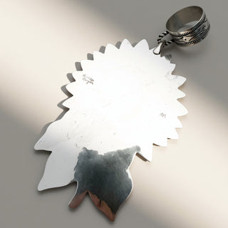 Silver pendant on a beige background