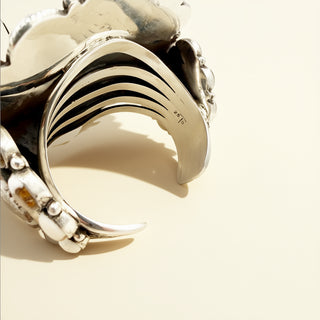 Silver cuff with a unique design on a beige background