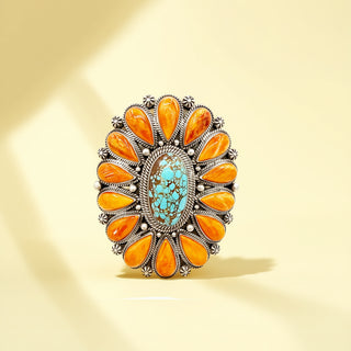 Decorative cuff with orange stones and turquoise center on a beige background