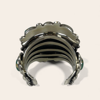 Silver bracelet with scalloped design on a white background