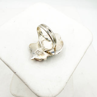 Silver ring with a star-shaped charm on a white surface