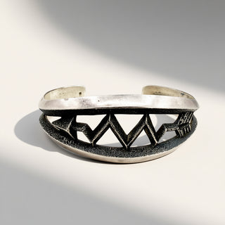 Silver bracelet with geometric design on a gray background