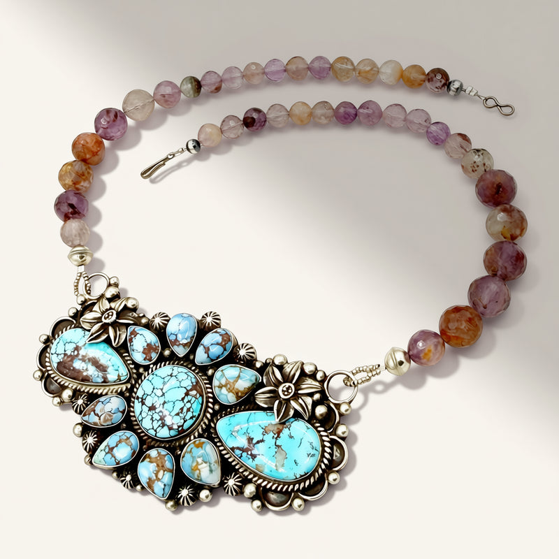 Necklace with turquoise pendant and multicolored beads on a white background