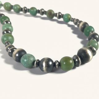 Necklace with green and silver beads on a white background
